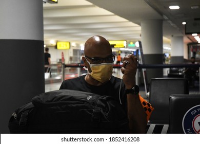 New York City, NY/US- 10/7/2020: A Group Of Passengers Traveling Together Adhere To CDC Guidelines Wearing Masks While Waiting For A Flight At JFK Airport.