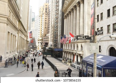 New York City, NY/USA - April 9, 2018: Wall Street sign and New York Stock Exchange around lunch hour in downtown.