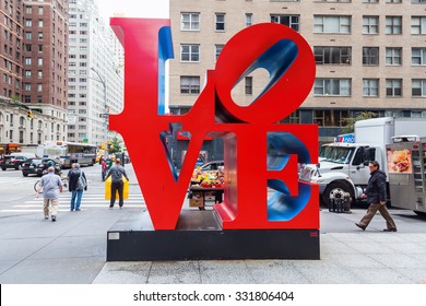 NEW YORK CITY - OCTOBER 07, 2015: Love Sculpture In Midtown Manhattan With Unidentified People. It Is From Artist Robert Indiana, A Pop Art Artist, His Media Include Paper And Cor-ten Steel Sculpture.