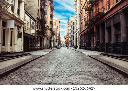 New York City old SoHo Downtown paving stone street with retail stores and luxury apartments