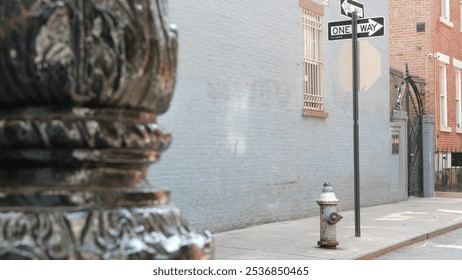 New York City oneway crossroad, Minetta street intersection one way arrow road sign. Manhattan Greenwich Village residential building architecture, NYC, United States. Blue brick wall, fire hydrant.