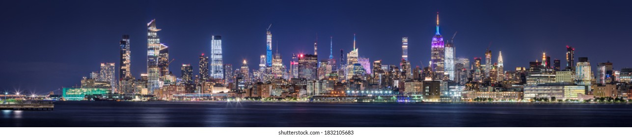 New York CIty panoramic cityscape of Midtown West skyscrapers at night along Hudson River Park. Manhattan, NY, USA