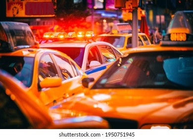 New York City Police Patrol Car Flashing Beacon Siren Lights In Busy NYC Traffic Jam With Yellow Taxi Cabs Cars. Urban Background.
