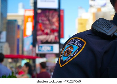 New York City - September 2016: NYPD sleeve patch shield on a police officer patrol Times Square Manhattan. Protect public from terror threats and ensure safety in central tourist landmark