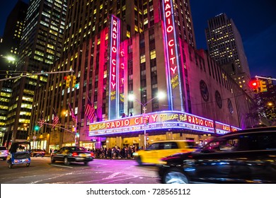 NEW YORK CITY - SEPTEMBER 28, 2017:  View Of Radio City Music Hall In Manhattan Seen At Night With Lights, Cars, Taxi's And Harry Styles On Marquee. 