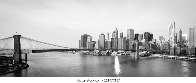 New York City skyline with  Brooklyn Bridge and  Lower Manhattan view in early morning sun light - Black and white