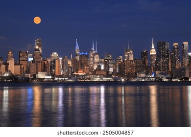 New York City skyline illuminated at dusk with orange full moon, view from Hudson River, USA - Powered by Shutterstock