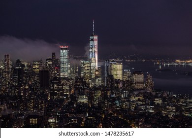 New York City skyline with lower Manhattan skyscrapers in storm at night.