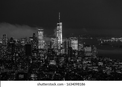 New York City skyline with lower Manhattan skyscrapers in storm at night. Black and white image.