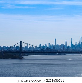 New York City Skyline (partial) And The Hudson River, Framed By The George Washington Bridge, As Shot From The Palisades. Blue Sky Above With A Light Haze, Sailboats Dot The River. Copy Space.