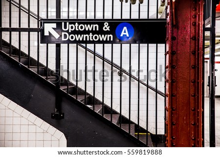 New York City Subway inside and underground with steps and directional sign for Uptown Downtown A train. 