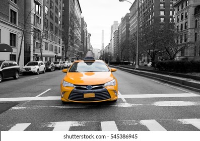New York City taxi in yellow color in the traffic light with building and car in background