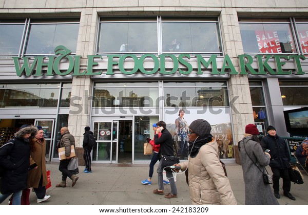 NEW YORK CITY - TUESDAY, DEC. 30,\
2014: Pedestrians walk past a Whole Foods supermarket. Whole Foods\
Market, Inc. specializes in natural and organic\
foods.