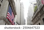 New York City, United States. Lower Manhattan Downtown Financial District urban architecture. Huge big American flag. Wall street Stock Exchange building, USA Stock Market trading.