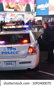 New York City, New York, United States - February, 20, 2018: Police Officer Getting Into NYPD Squad Car At Night In Times Square, Manhattan.