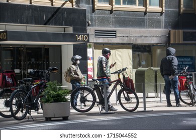 New York City, United States - April 23rd, 2020: Delivery Workers On Bikes In NYC During Covid-19 Pandemic