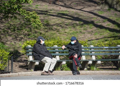 New York City, United States - April 23rd, 2020: Two Elderly Men With Face Masks Sit In Park Bench In Central Park