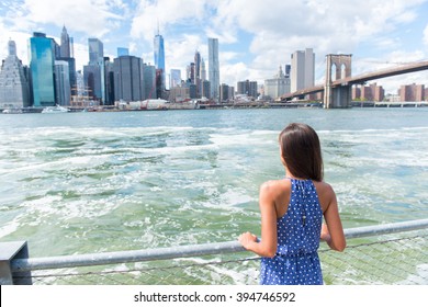 New York City Urban Woman Enjoying View Of Downtown Manhattan Skyline From Brooklyn Park Living A Happy Lifestyle Walking During Summer Travel In USA. Female Asian Tourist In Her 20s.