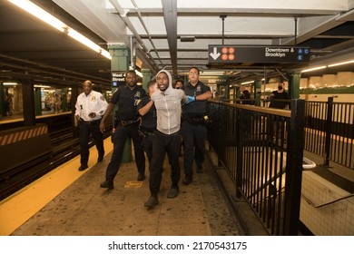 NEW YORK CITY, USA - 23 JUNE 2022: Homeless Man Blocking Subway Traffic On Rails And Trying To Escape From The Police