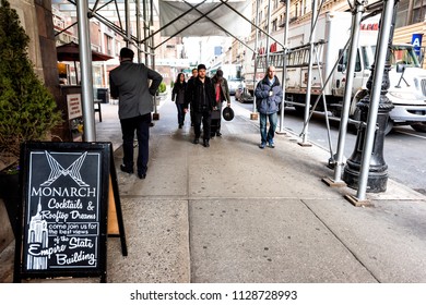 New York City, USA - April 6, 2018: Manhattan NYC Buildings Of Midtown Herald Square, Avenue Road, Signs For Monarch Bar, People Walking On 35th Street Sidewalk Under Construction Scaffold