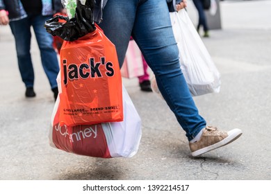 New York City, USA - April 6, 2018: Manhattan NYC Sidewalk In Midtown On 6th Avenue Road And Closeup Of People Legs Walking Woman Carrying Jack's And JCPenney Bag