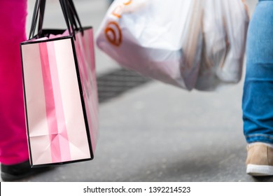 New York City, USA - April 6, 2018: Manhattan NYC Sidewalk In Midtown Herald Square On 6th Avenue Road And Closeup Of People Walking Woman Carrying Pink Victorias Secret Bag