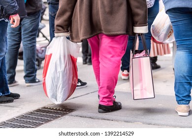 New York City, USA - April 6, 2018: Manhattan NYC Sidewalk In Midtown On 6th Avenue Road And Closeup Of People Walking Woman Carrying Pink Victorias Secret And JCPenney Bag