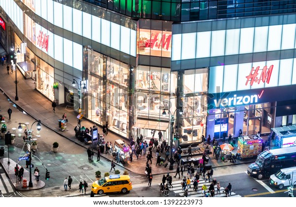 New\
York City, USA - April 6, 2018: High angle aerial view of H&M\
store at intersection of NYC Herald Square midtown with crowd of\
people crossing crosswalk and traffic cars at\
night