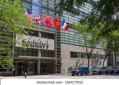 New York City / USA - July 26, 2010: People Walking By The Sotheby's Auction House In New York City With A Row Of International Flags Over The Entrance