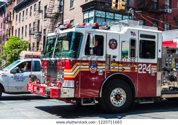 New York City,\
USA - July 26, 2018: Fire truck circulating on a street with people\
around in New York City,\
USA