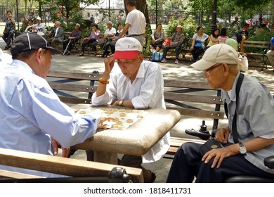 New York City, USA - June 29, 2016: Elderly Men Playing Xiangqi Or Chinese Chess In The Park In Chinatown