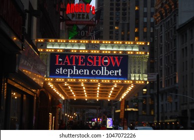 New York City, USA - March 10 2018: Manhattan NYC Buildings In Times Square, Broadway Street Avenue Road, Signs For Colbert Late Show, Angelo's Pizza Italian Restaurant, Marquee / Theatre At Night