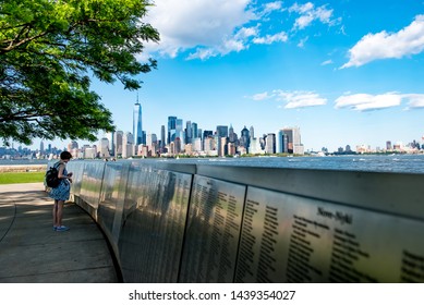 New York City, New York / USA - May 27 2019: A Woman Looks At The Names On The American Immigrant Wall Of Honor At The Ellis Island National Museum Of Immigration