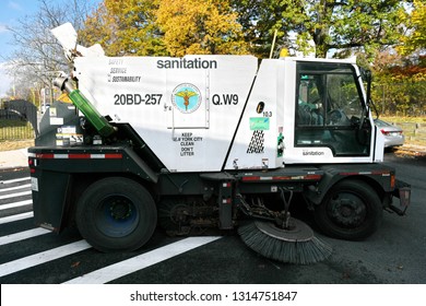 New York City, USA - November 16, 2017: A street sweeper vehicle cleans a road in the Kew Gardens borough of Queens. The NYC Department of Sanitation is responsible for cleaning the city's streets.