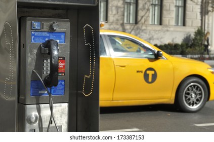 NEW YORK CITY, NEW YORK, USA - NOVEMBER 15, 2012: Old Fashioned Pay Phone On A New York City Street With A Taxi Passing By.November 15, 2012,New York