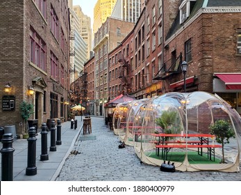 New York City, USA - November 26, 2020: Restaurants and bars enforce social distance safety with outdoor dining bubbles on Stone Street in Manhattan during the coronavirus pandemic.
