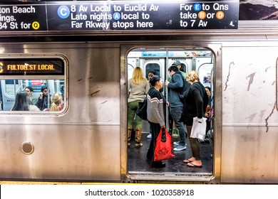 New York City, USA - October 28, 2017: People in underground platform transit in NYC Subway Station on commute with train, people crammed crowd with open closing doors