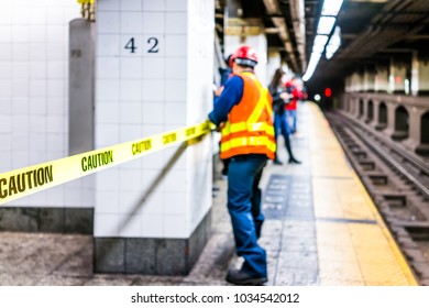 New York City, USA - October 29, 2017: Employee Worker Inspecting Leak In Underground Transit Empty Large Platform In NYC Subway Station In Grand Central, Caution Tape