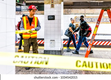 New York City, USA - October 29, 2017: Employee Worker Inspecting Leak In Underground Transit Empty Large Platform In NYC Subway Station In Grand Central, Ladder, Caution Tape
