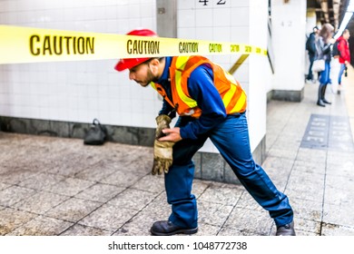 New York City, USA - October 29, 2017: Employee Worker Inspecting Leak In Underground Transit Empty Large Platform In NYC Subway Station In Grand Central, Ladder, Caution Tape, Walking Under