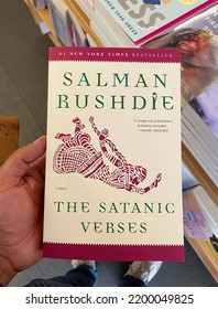 New York City, New York, USA - A Reader Holding A Closeup Photograph Of The Award Winning Best Selling And Controversial Novel By Author Salman Rushdie, The Satanic Verses