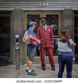  New York City, New York, USA - September 8 2018: Friendly Faced Doorman Talking To A Male Outside Empire State Building                          