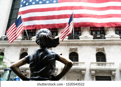 New York City/USA - September 2, 2019: Focus In On Fearless Girl Looking Up At The New York Stock Exchange(NYSE) In Lower Manhattan's Financial District With American Flag.