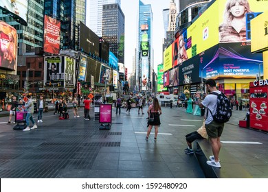 New York City/USA - September 2, 2019: Street Level View Of Times Square With Young Group Of Tourists Photographing The Scenery.