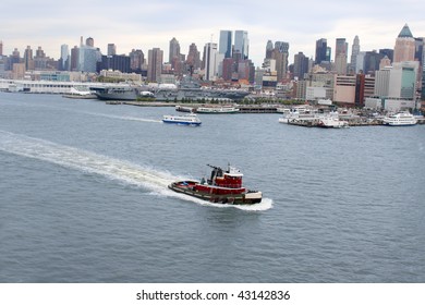  New York famous skyline and boat docks along the Hudson River with tug boat or pilot boat in the forefront