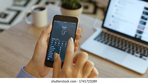 NEW YORK - January 17, 2016: Close Up Woman Hands Checking Weather Forecast On Smartphone. Weather App On Iphone Device.