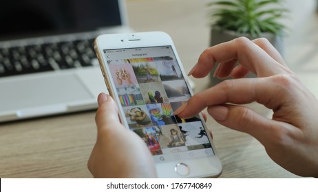 New York - July 15, 2016: Social Media. Close Up Shot Of Woman Hands Scrolling Pictures, Photos In Instagram Application Using Smart Phone In The Office.