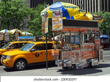 NEW YORK, NEW YORK - June 29, 2014:  Hot Dog Cart.  A Hot Dog Cart Selling Hot Dogs, Soft Pretzels And Drinks On A Street Corner In New York City.