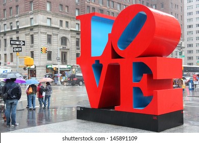 NEW YORK - JUNE 7: People walk past Love sculpture in rain on June 7, 2013 in New York. The famous monument by Robert Indiana is located on 6th Avenue.