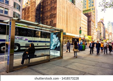 New York Manhattan, USA 18 May 2019. Woman Waiting At The Bus Station With Advertising Board Of Chanel Brand And It's Time To Go Home After Work Of City Life Downtown In New York